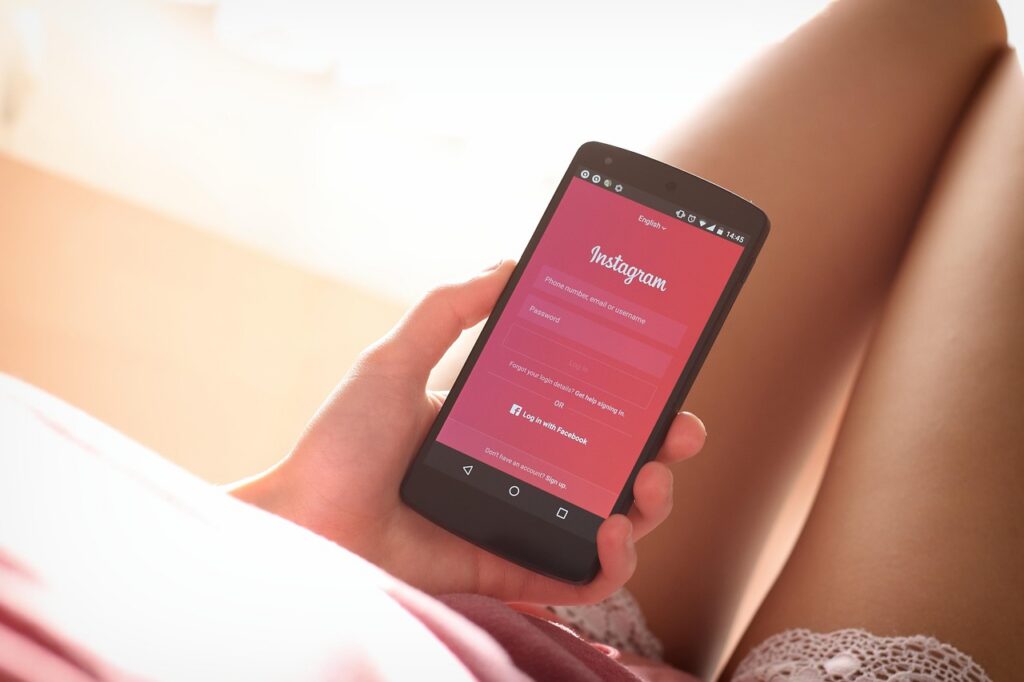 Mulher usando celular com aplicativos de redes sociais