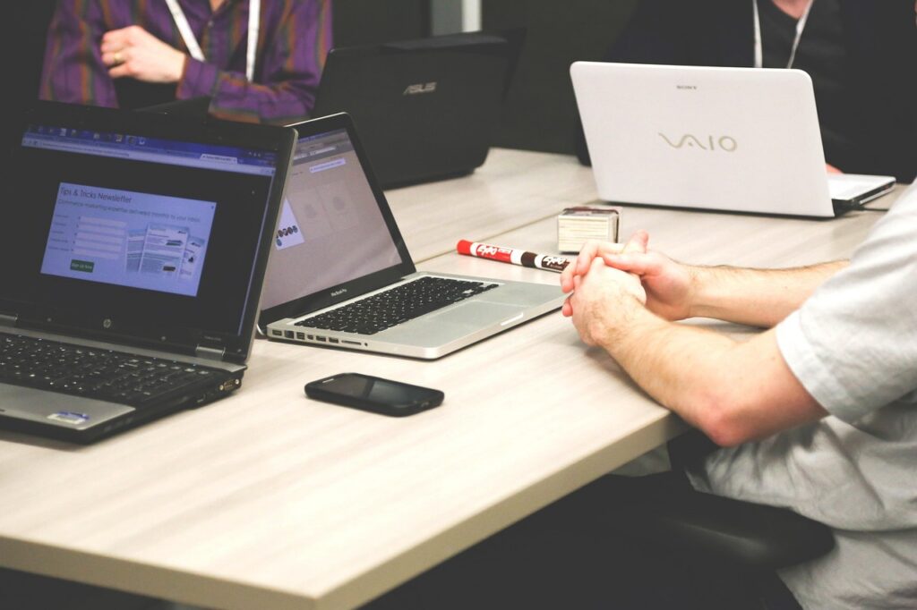 Equipe de vendas reunida analisando dados em laptop