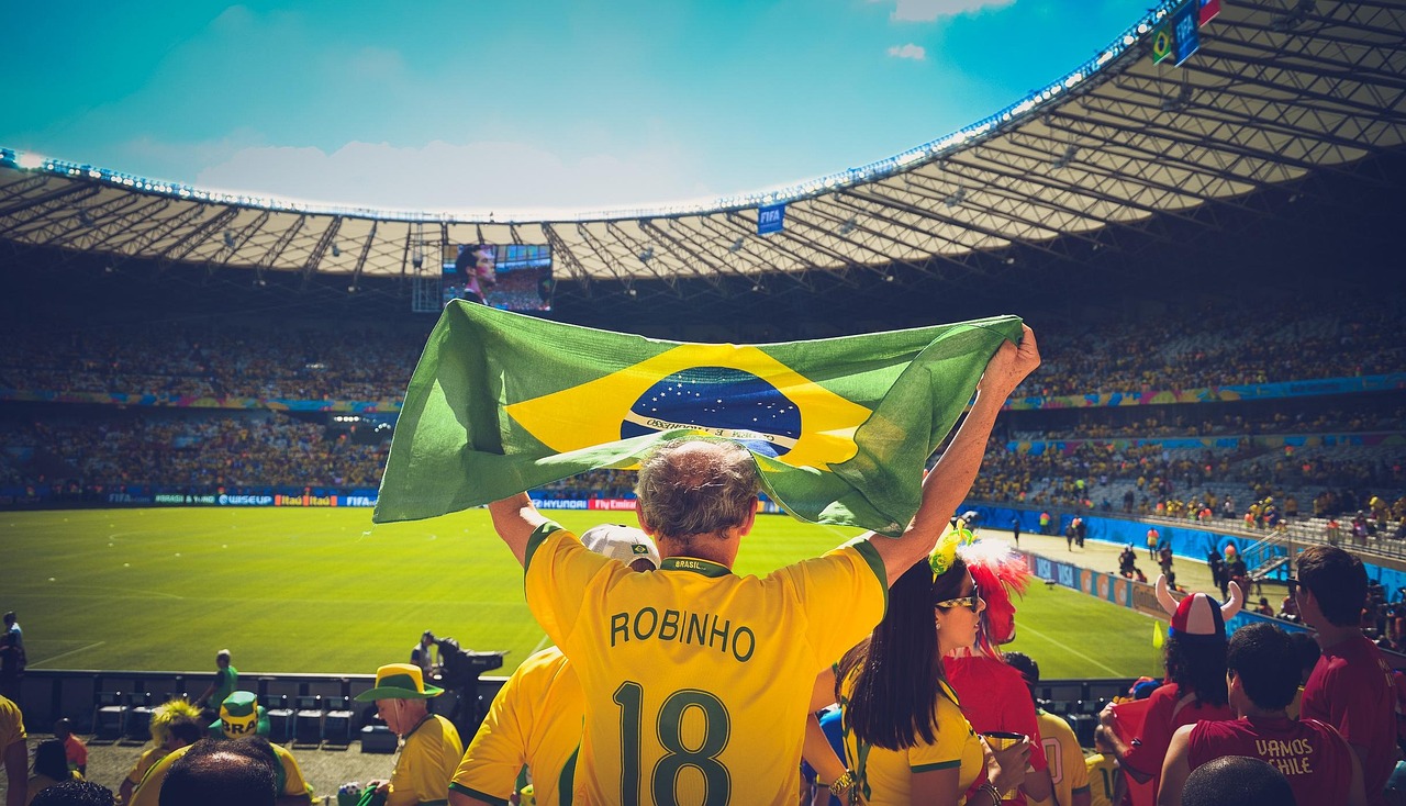 Torcedores com bandeira do Brasil em estádio de futebol lotado