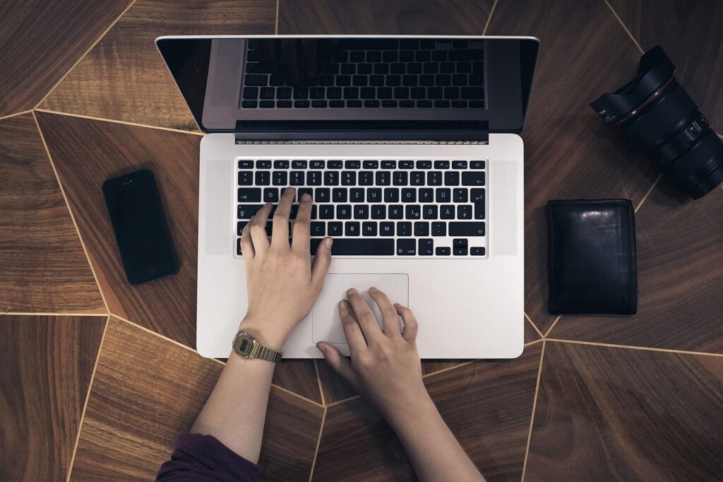 Pessoa digitando em laptop em ambiente de trabalho